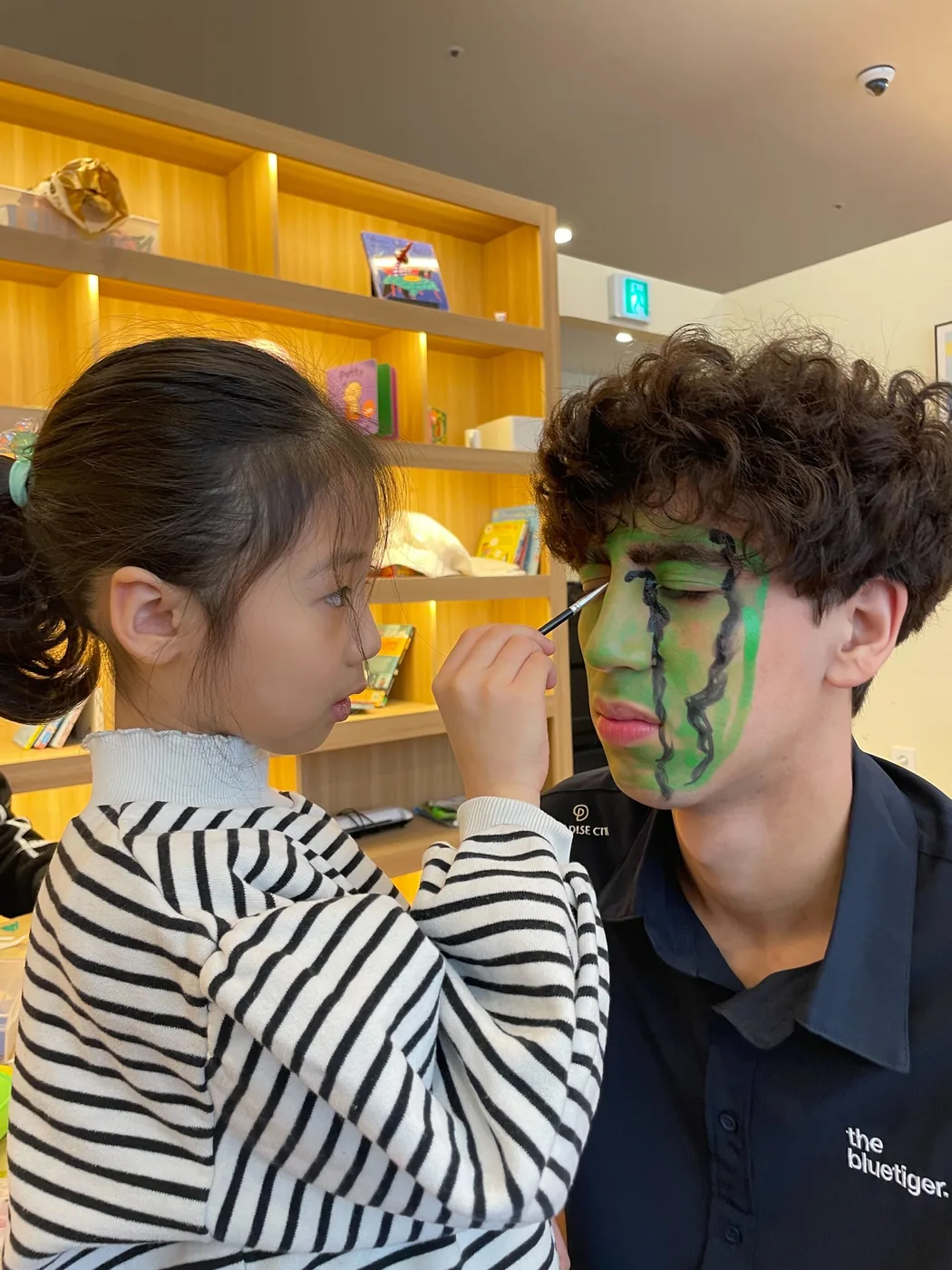 얼굴에 그림을 그려주는 원어민 선생님과 아이