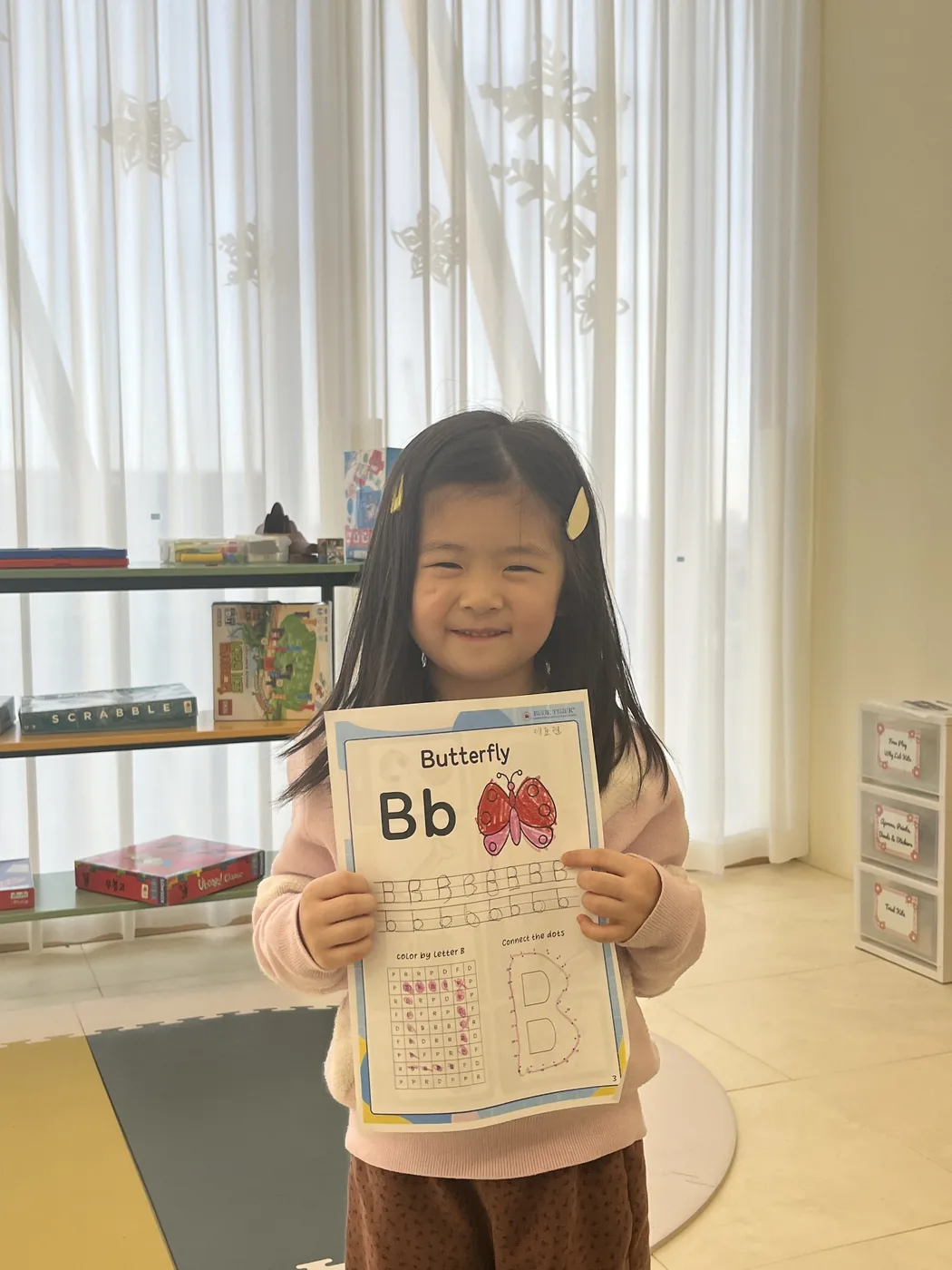 완성한 활동지를 들어 보이며 웃는 아이
